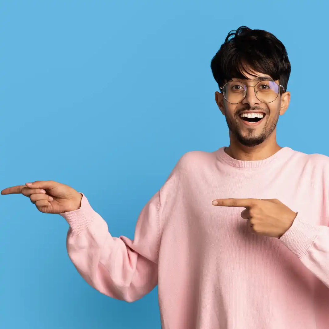 Man in a pink sweater pointing to himself against a blue background